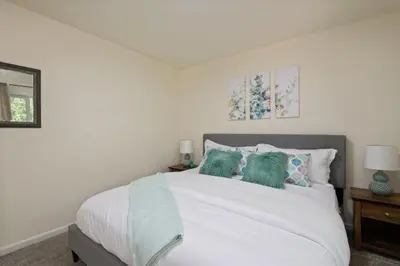 a bedroom with a white bed with green pillows at Fire Pit Funhouse 2 Master Suites Game Rm in Westminster