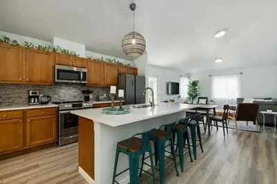 an open kitchen with a large island with bar stools at Fire Pit Funhouse 2 Master Suites Game Rm in Westminster