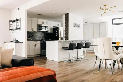 a kitchen and living room with a table and chairs at Deluxe Larimer Square Retreat - Walk Everywhere! in Denver