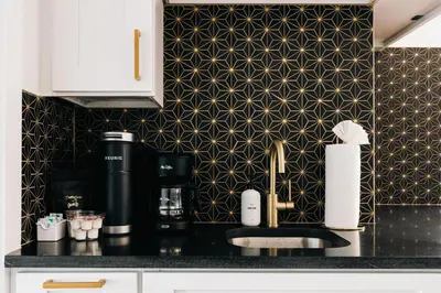 a kitchen with a black counter with a black and gold wallpaper at Deluxe Larimer Square Retreat - Walk Everywhere! in Denver