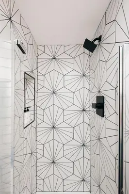 a shower with a black and white patterned wall at Deluxe Larimer Square Retreat - Walk Everywhere! in Denver