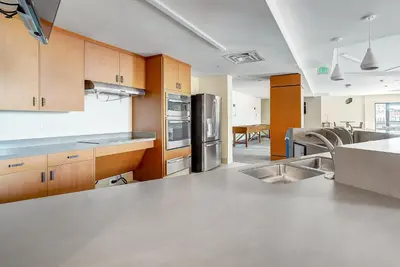 a kitchen with stainless steel appliances and wooden cabinets at Deluxe Larimer Square Retreat - Walk Everywhere! in Denver