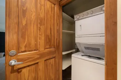 a door leading into a small kitchen with a washer and dryer at Premium Unit 2801 - Zephyr Mountain Lodge condo in Winter Park