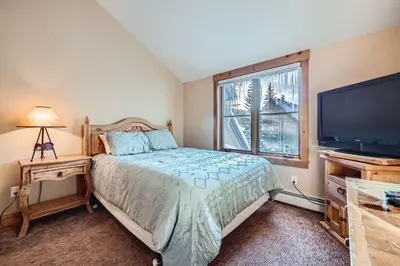 a bedroom with a bed and a flat screen tv at 8712 Ski Tip Townhomes townhouse in Keystone