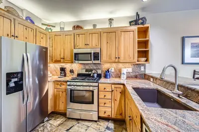 a kitchen with wooden cabinets and a stainless steel refrigerator at 8712 Ski Tip Townhomes townhouse in Keystone