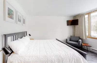 a bedroom with a white bed and a chair at 1765 Montezuma condo in Keystone