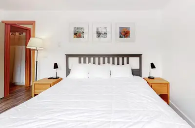 a bedroom with a large white bed with two night stands at 1765 Montezuma condo in Keystone