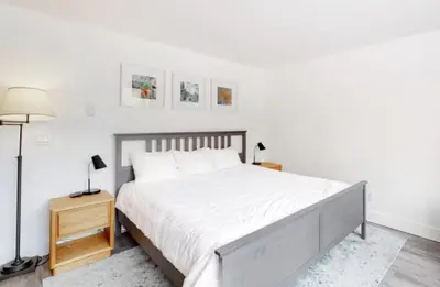 a white bedroom with a large bed and a lamp at 1765 Montezuma condo in Keystone