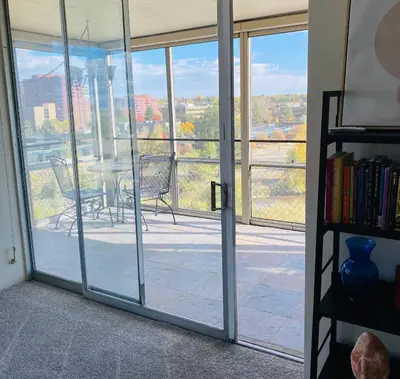 a room with sliding glass doors with a table and chairs at Cherry Creek Condo in Denver