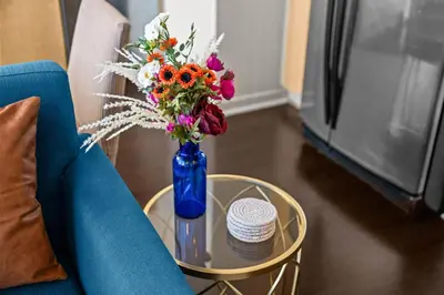 a blue vase with flowers on a table next to a blue couch at 1700 Bassett, Unit 711 in Denver