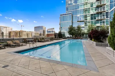 a large swimming pool in a city with a tall building at 1700 Bassett, Unit 711 in Denver