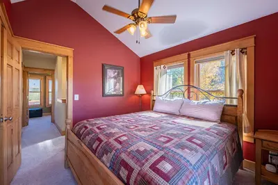 a bedroom with a bed and a ceiling fan at Riverbend views ten feet away in Granby