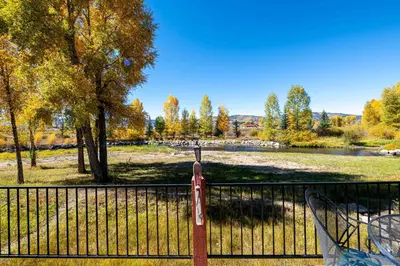 a fence with a sign in front of a park at Riverbend views ten feet away in Granby