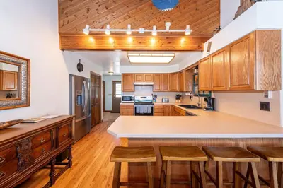a large kitchen with wooden cabinets and a large island at Take a break from it all escape to the mountains in Grand Lake
