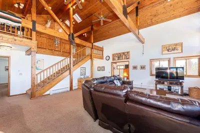 a living room with a leather couch and a staircase at Take a break from it all escape to the mountains in Grand Lake