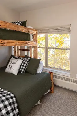 a bedroom with a bunk bed and a window at Base Camp Ski Slope Views Granby Ranch in Granby