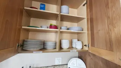 a cupboard with plates and bowls in it at Base Camp Ski Slope Views Granby Ranch in Granby