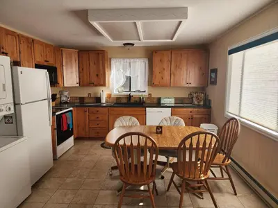 a kitchen with a table and chairs and a white refrigerator at Rocky Mountain National Park Entrance one Mile in Grand Lake