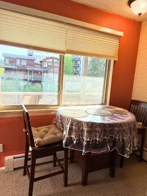a table and a chair in a room with a window at Riverfront Retreat Just 7 Minutes from the Resort, with a Hot Tub and Pool walk to downtown in Winter Park