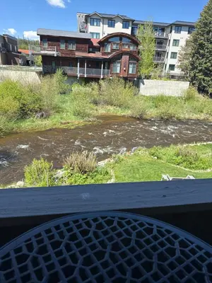 a view of a river with a building in the background at Riverfront Retreat Just 7 Minutes from the Resort, with a Hot Tub and Pool walk to downtown in Winter Park