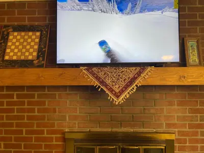 a tv on top of a brick fireplace at Riverfront Retreat Just 7 Minutes from the Resort, with a Hot Tub and Pool walk to downtown in Winter Park