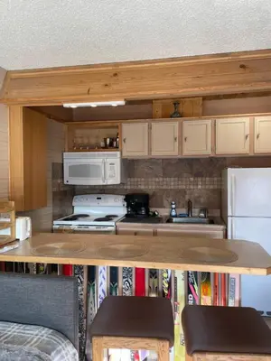 a kitchen with a counter with a stove and a refrigerator at Riverfront Retreat Just 7 Minutes from the Resort, with a Hot Tub and Pool walk to downtown in Winter Park