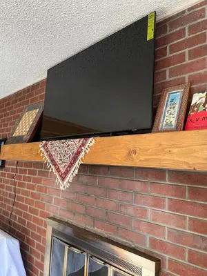 a flat screen tv on top of a brick fireplace at Riverfront Retreat Just 7 Minutes from the Resort, with a Hot Tub and Pool walk to downtown in Winter Park