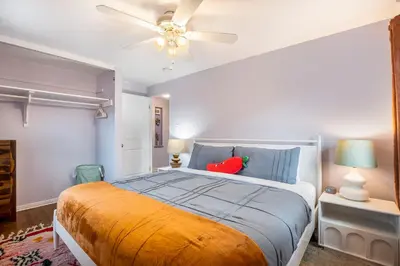 a bedroom with a bed and a ceiling fan at The Funky Flamingo - HOT TUB - BBQ - Fire Pit in Arvada