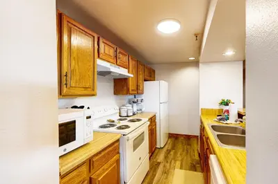a kitchen with white appliances and wooden cabinets at Marina Place 413 in Dillon