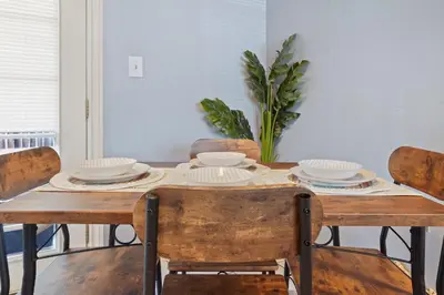 a dining room table with chairs and plates on it at Vibrant and spacious 3 level home by park in Northglenn