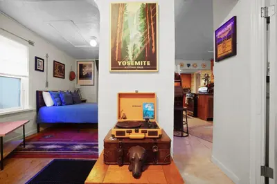 a living room with a room with a blue couch at Whimsical Berkeley Bungalow in Denver
