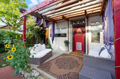 a front porch with a red door and a couch at Whimsical Berkeley Bungalow in Denver