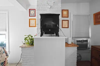 a fireplace in a living room with a stove at Whimsical Berkeley Bungalow in Denver