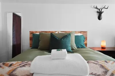 a bed with a pile of towels on top of it at Whimsical Berkeley Bungalow in Denver