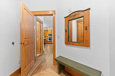 a hallway with a mirror and a wooden door at Lone Eagle 3012 in Keystone