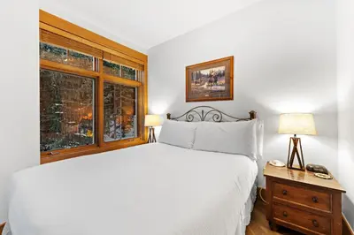 a bedroom with a white bed and a window at Lone Eagle 3012 in Keystone