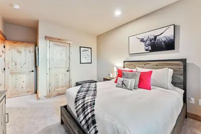 a bedroom with a large bed with red pillows at Modern Keystone Townhome Next to River Run Village in Keystone