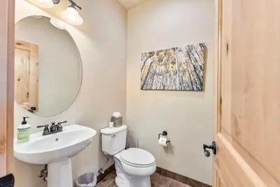 a bathroom with a sink and a toilet and a mirror at Modern Keystone Townhome Next to River Run Village in Keystone