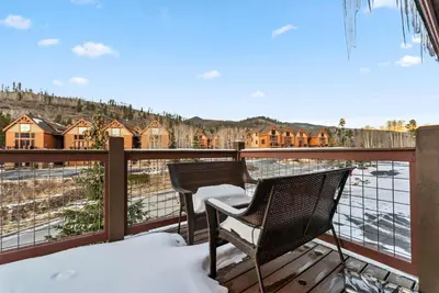 a balcony with a table and a chair in the snow at Modern Keystone Townhome Next to River Run Village in Keystone