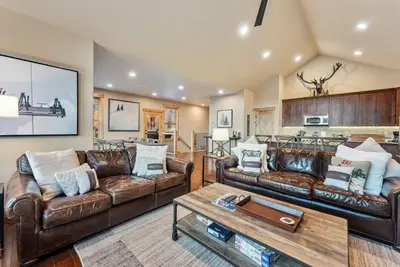 a living room with two leather couches and a table at Modern Keystone Townhome Next to River Run Village in Keystone