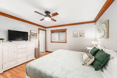 a bedroom with a bed and a flat screen tv at Foothills Escape - 10 min to Red Rocks in Lakewood