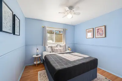 a blue bedroom with a bed and a window at Foothills Escape - 10 min to Red Rocks in Lakewood