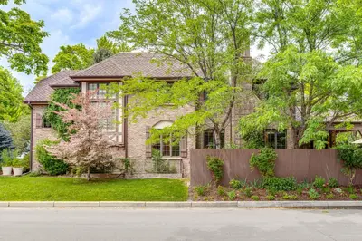 a brick house with a fence in front of it at Walk to DU, Dining and Parks Spacious Denver Home! in Denver
