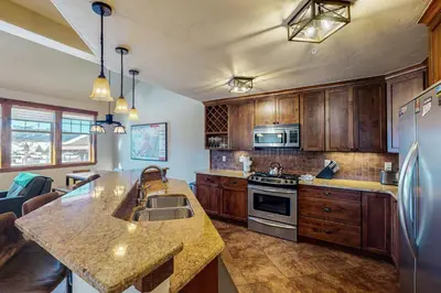 a kitchen with wooden cabinets and a counter top at Byers Peak Mountain Escape – Winter Park Retreat with Scenic Views in Fraser