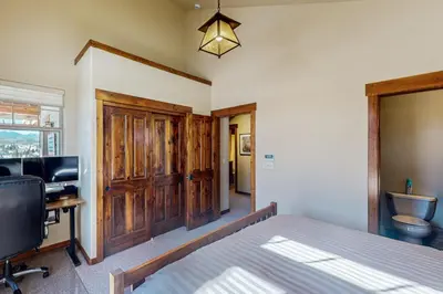 a bedroom with a bed and a desk and a television at Byers Peak Mountain Escape – Winter Park Retreat with Scenic Views in Fraser