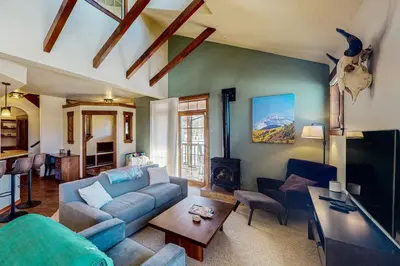 a living room with a blue couch and a table at Byers Peak Mountain Escape – Winter Park Retreat with Scenic Views in Fraser