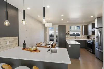 a kitchen with a large white island in the middle at Mountain View Home with King Beds and Rooftop Deck in Fort Collins