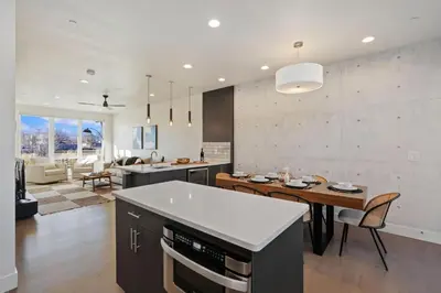 a kitchen and living room with a table and a dining room at Mountain View Home with King Beds and Rooftop Deck in Fort Collins