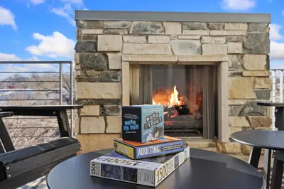 a stack of books sitting on a table in front of a fireplace at Mountain View Home with King Beds and Rooftop Deck in Fort Collins