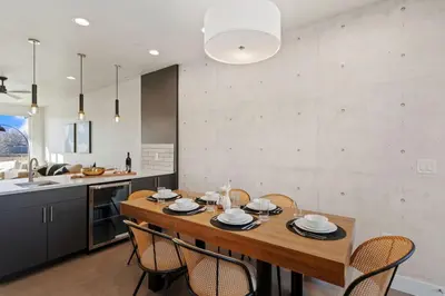 a kitchen and dining room with a wooden table and chairs at Mountain View Home with King Beds and Rooftop Deck in Fort Collins